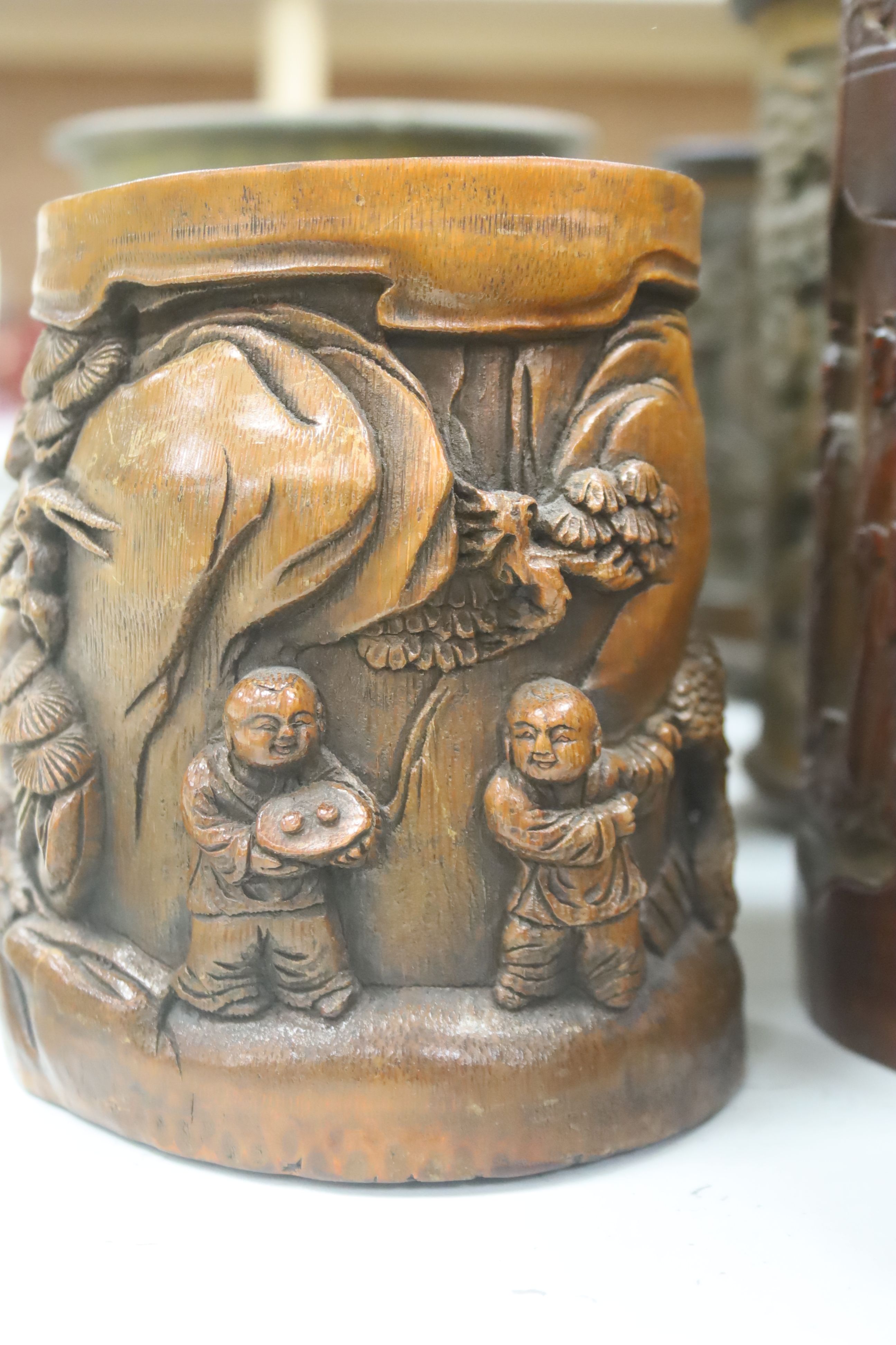 Six 19th/20th century Chinese carved brush pots and a similar carved tea caddy, tallest 20cm